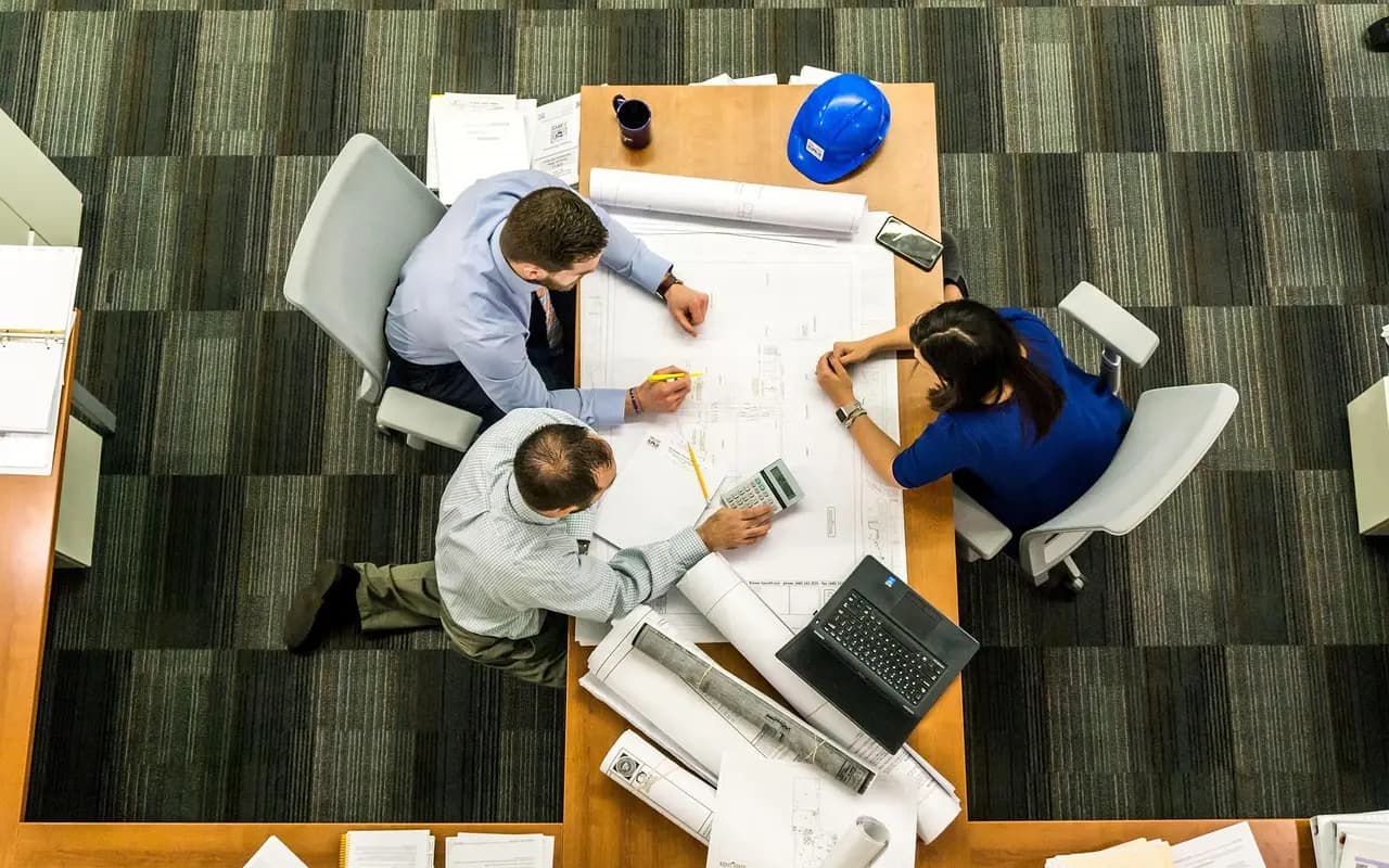 Team reviewing plans at a table with hard hats
